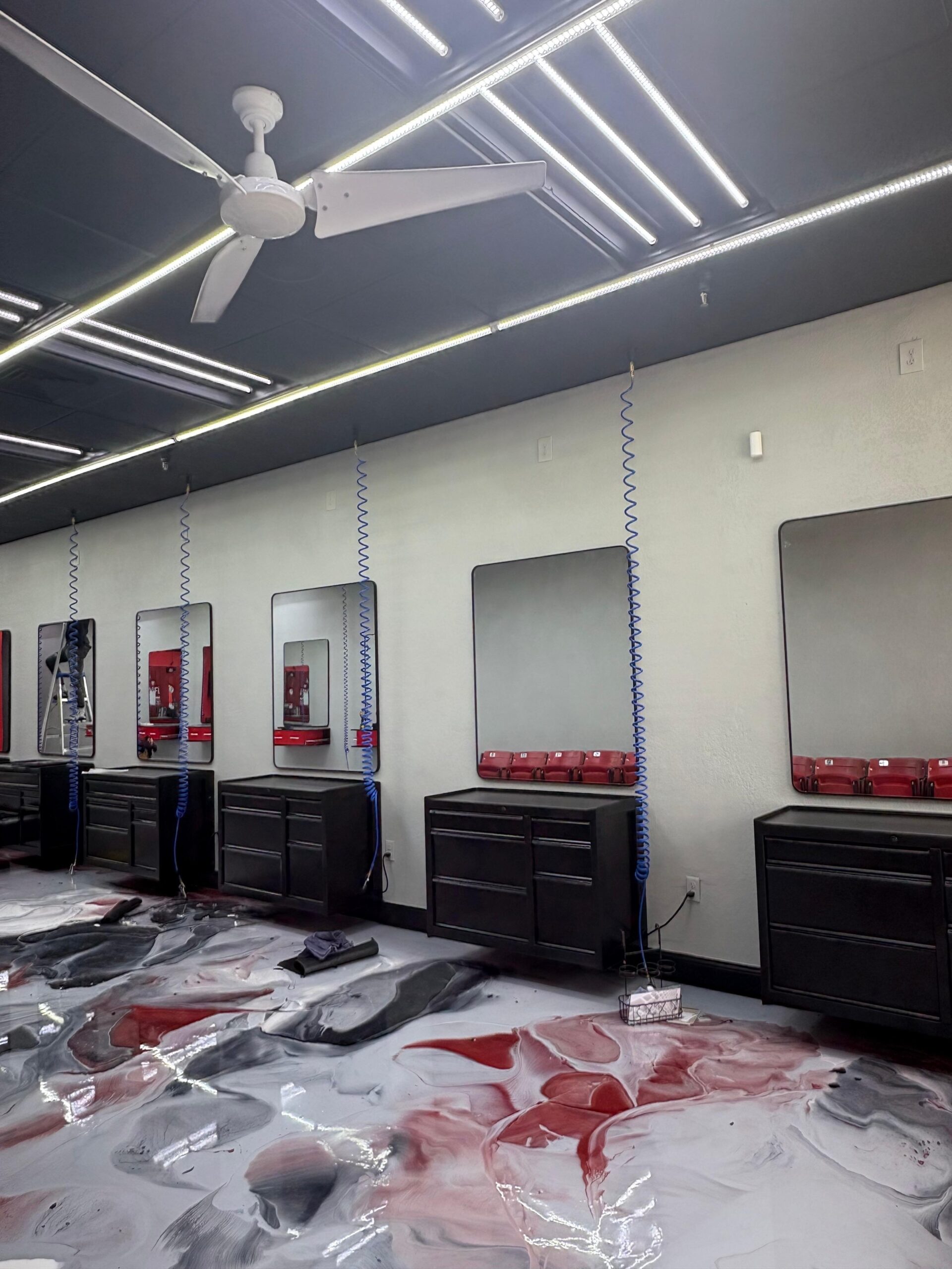 Premium barbershop with charcoal ceiling, LED tube lighting and black vanity stations, commercial painting by Third Coat Orlando