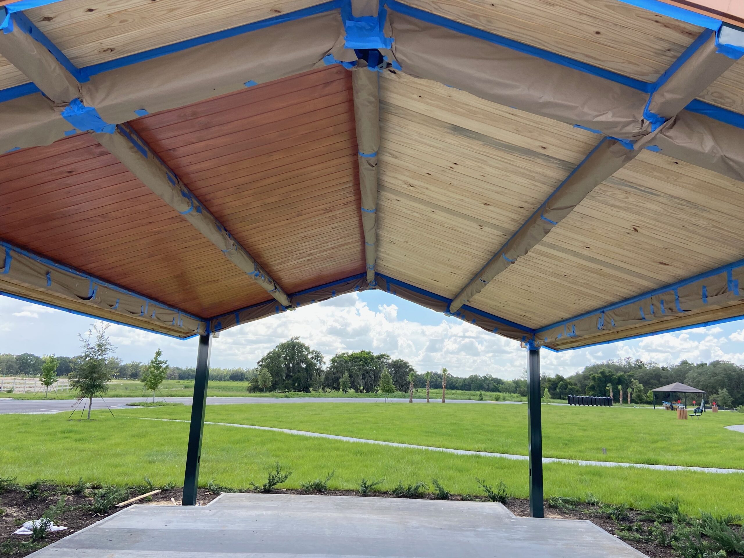 Commercial wood staining in progress on park pavilion ceiling, before and after comparison visible, Third Coat Orlando