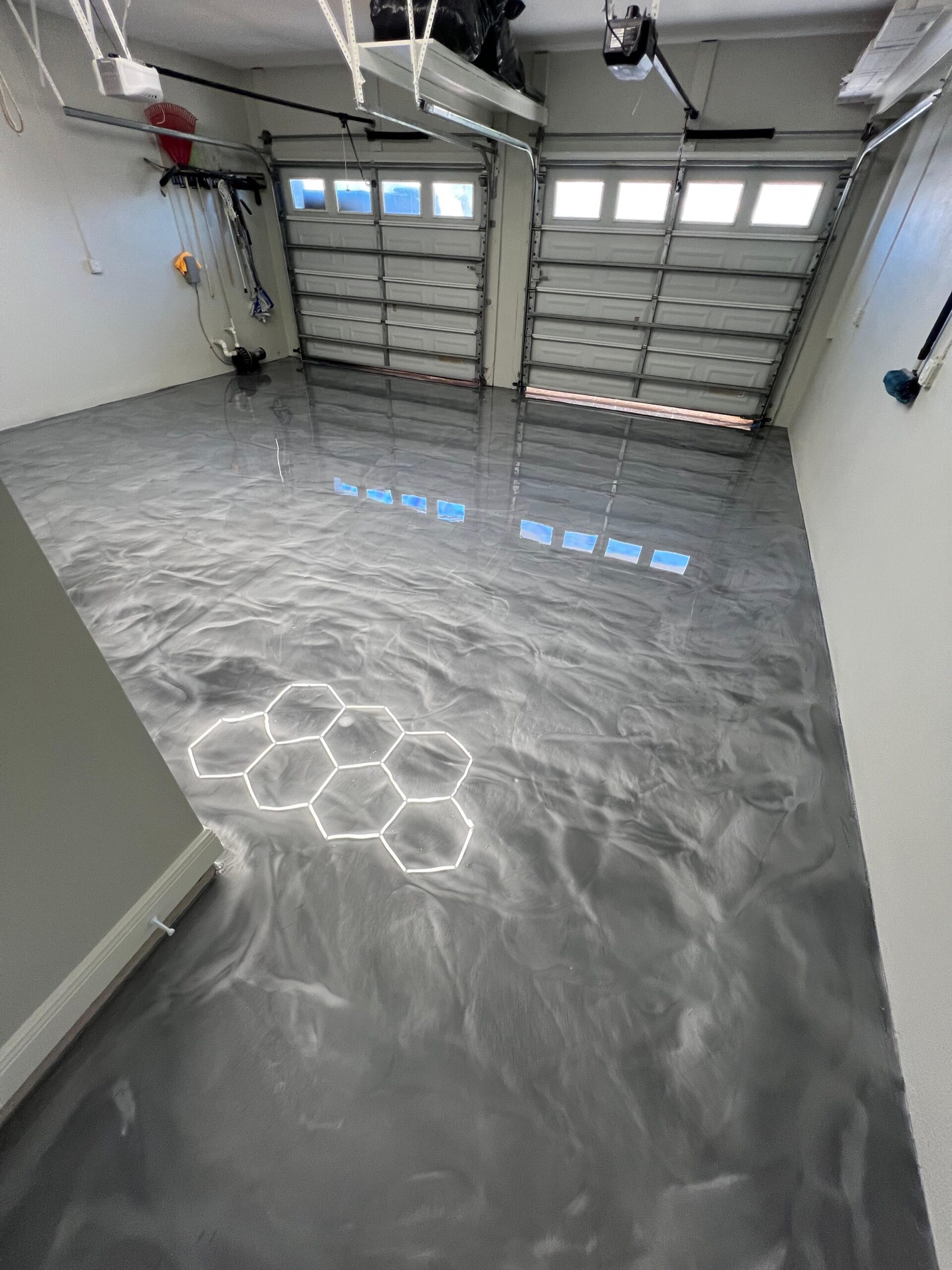 Metallic epoxy garage floor in silver gray with high-gloss finish. Third Coat Orlando