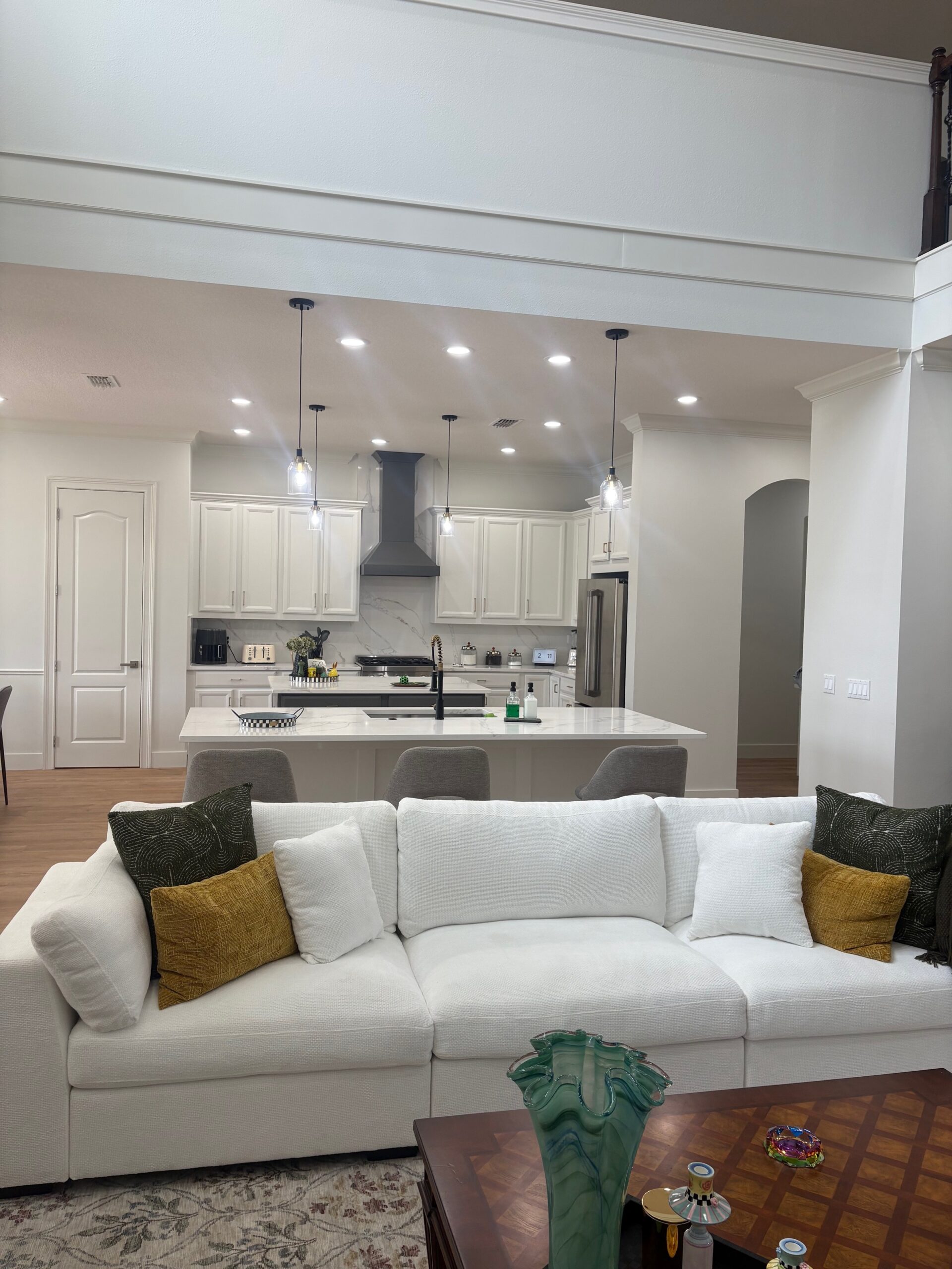 White kitchen refreshing with new gray range hood and decorative island panels. Third Coat Orlando