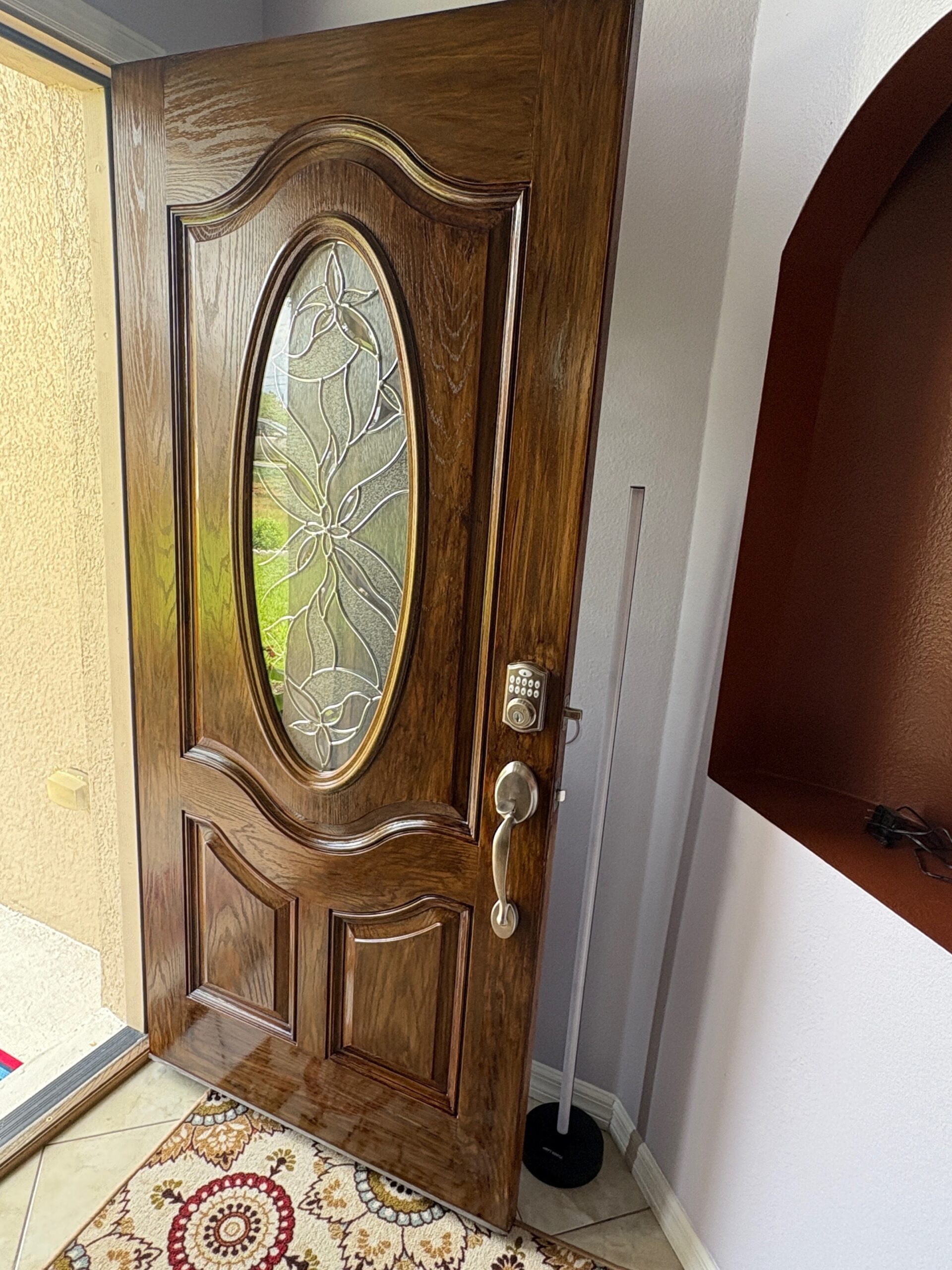 Front door wood staining with rich brown stain and stained glass. Third Coat Orlando